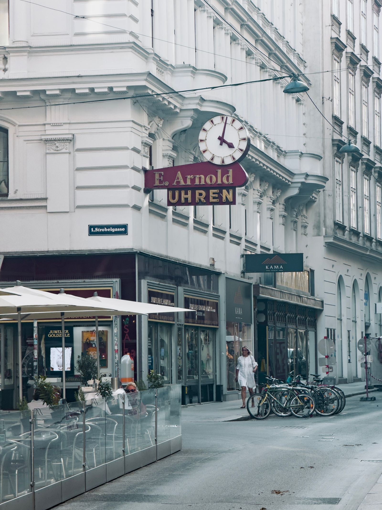 Wiener Gasse mit Uhr und Schanigarten
